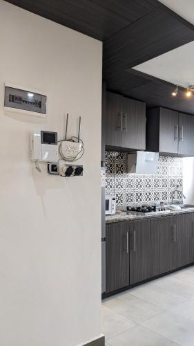 a kitchen with brown cabinets and a white wall at Toilcam in Buea