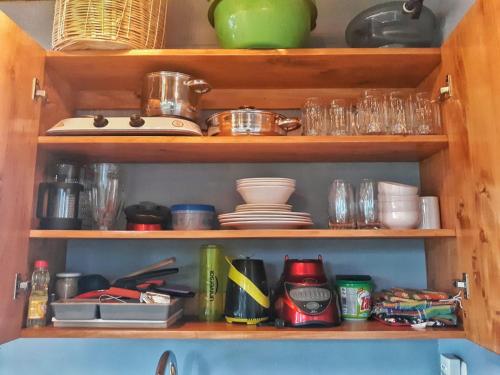 a wooden shelf with dishes and dishes on it at Refugio del Volcan Casitas in San Pedro La Laguna