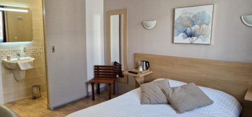 a bedroom with a bed and a bathroom with a sink at Hôtel Du Commerce in Fécamp
