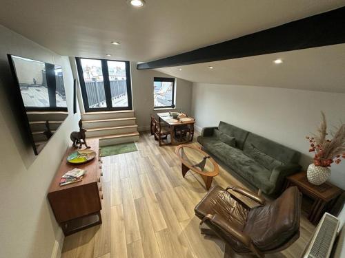 ein Wohnzimmer mit einem grünen Sofa und einem Tisch in der Unterkunft The Curious Apartment, Cheltenham in Cheltenham