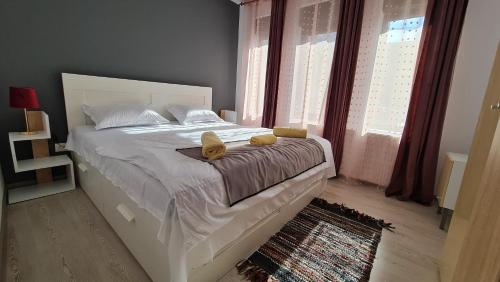ein Schlafzimmer mit einem Bett mit zwei Schuhen drauf in der Unterkunft Pomiculturii Residence 1 in Timişoara