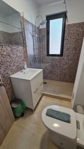 ein Badezimmer mit Toilette und Waschbecken und einem Fenster in der Unterkunft Pomiculturii Residence 1 in Timişoara