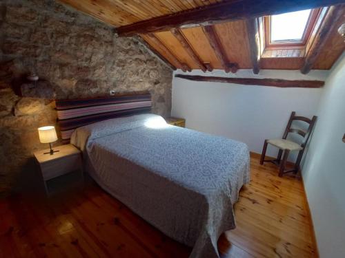 a bedroom with a bed and a table and a chair at La Majada del Puente in El Royo