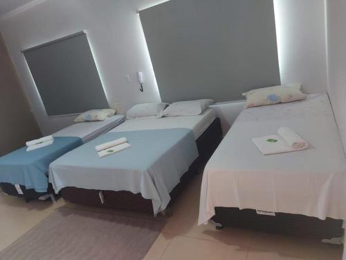 two beds in a hotel room with towels on them at Hotel Pousada Aeroporto in Goiânia