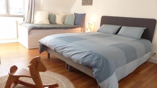 a bedroom with a bed and a chair and a couch at Ravissante maison de pêcheur Quiberon/Saint Julien in Quiberon