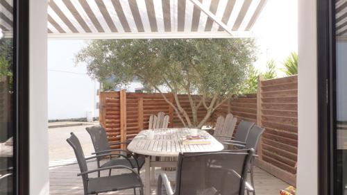 une table blanche et des chaises sur une terrasse dans l'établissement Ravissante maison de pêcheur Quiberon/Saint Julien, à Quiberon