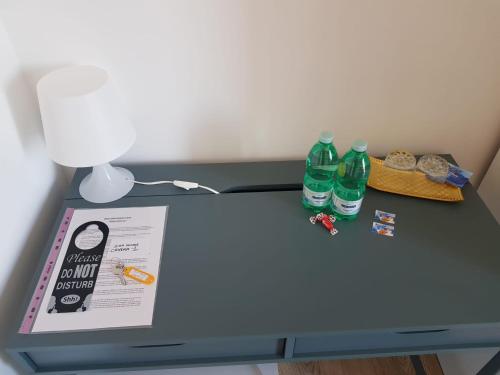 a table with a lamp and two bottles of water on it at B&B Gisa House in Pomigliano dʼArco