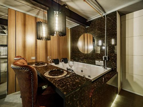 a bathroom with a tub and a sink and a mirror at Hotel One Laureles in Medellín