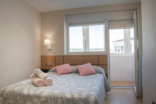 Un dormitorio con una cama con almohadas rosas. en The View - Apartamento reformado con vistas a la Catedral - leonapartamentos, en León