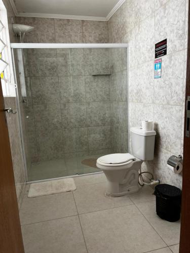 a bathroom with a toilet and a glass shower at Pousada Solar Teresa in Petrópolis