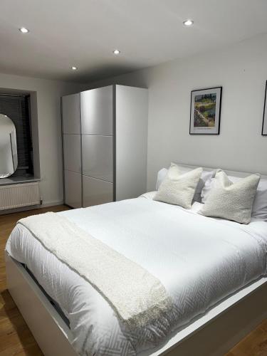 een groot wit bed met witte lakens en kussens bij Town House in Central Birmingham - Smart TV - Free Parking onsite - 5 Guests in Birmingham