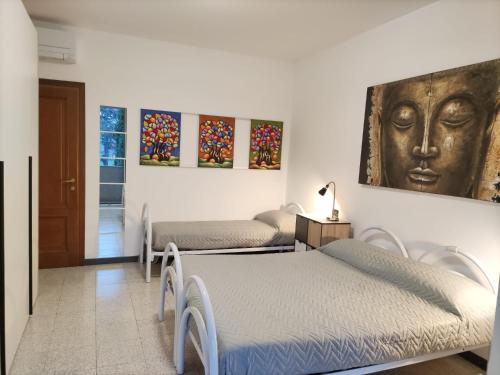 a room with two beds and a painting on the wall at B&B Ariosto 26 in Rho