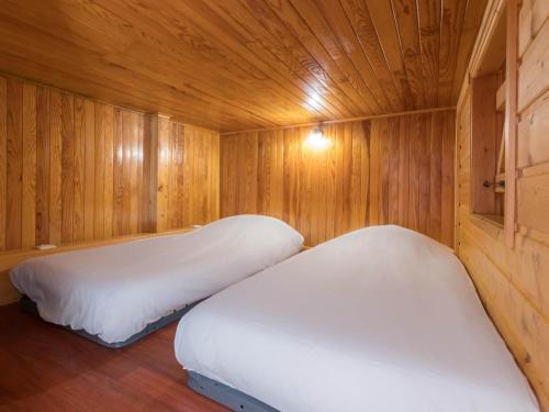 a room with two beds in a wooden cabin at Studio Courchevel 1650, 1 pièce, 5 personnes - FR-1-563-31 in Courchevel