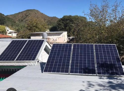 un grupo de paneles solares en el techo de una casa en La Bicicleta solar casa abierta en Villa Independencia