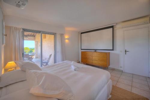 Cette chambre comprend 2 lits et un grand écran. dans l'établissement IMMOGROOM - Luxury Villa - Swimming pool - Fitness - AC, à Vallauris