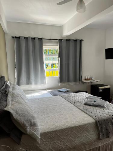 a bedroom with a large bed and a window at Pousada Solar Teresa in Petrópolis