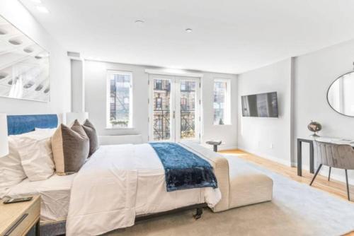 um quarto branco com uma cama e uma secretária em Luxe Studio with Charming Juliet Balcony em Nova York