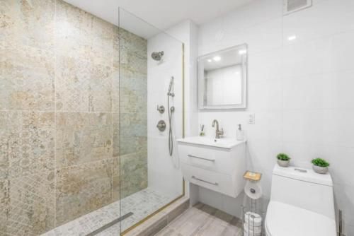 uma casa de banho com um chuveiro, um WC e um lavatório. em Luxe Studio with Charming Juliet Balcony em Nova York