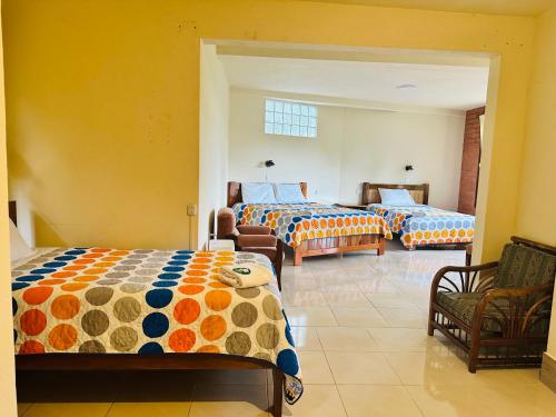 a room with two beds and a living room with a couch at La Casa de Cecilia Mindo in Mindo