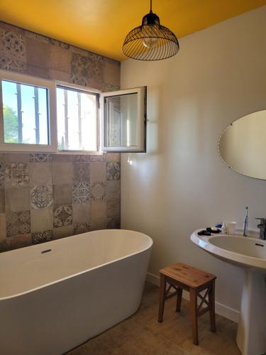 La salle de bains est pourvue d'une grande baignoire et d'un lavabo. dans l'établissement Chambre confortable vue sur mer, à Hyères