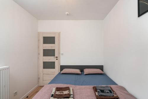 a bedroom with a blue bed and a white wall at ApartWro 3th - apartament przy dworcu głównym PKP, balkon, garaż, rowery in Wrocław