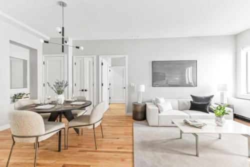 a white living room with a white couch and a table at Top Notch 2BR in Upper East Mins to Central Park in New York