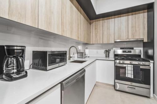 a kitchen with a stove top oven and a blender at Top Notch 2BR in Upper East Mins to Central Park in New York