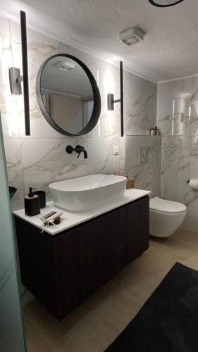 a bathroom with a sink and a toilet and a mirror at K&M 40 Ekklision A’ in Drama