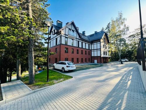 シュクラルスカ・ポレンバにあるApartament ONE Szklarska Porębaの白い車が目の前に停まっている家