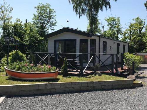 a tiny house with a boat in the yard at Sherwood Lodge in Cheddar