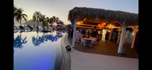 einen Pool in einem Resort mit einem Restaurant in der Unterkunft Vue Mer & Rocher - Okavango Blue Studio in Le Diamant