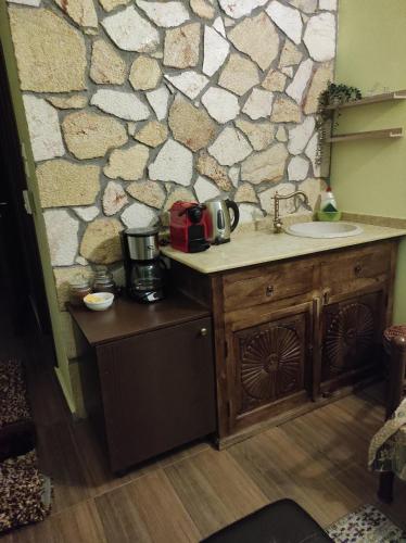 a kitchen with a sink and a stone wall at Voreio Selas in Synikia Mesi Trikalon