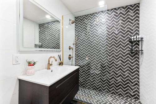 a bathroom with a black and white chevron shower at Luxury 3BR Duplex w Private Patio in Upper East in New York
