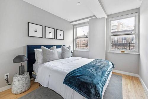 a bedroom with a large bed and two windows at 3BR Penthouse Suite with Massive Private Rooftop in New York