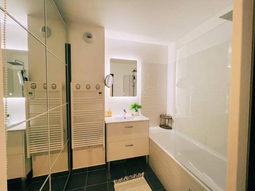 een badkamer met een bad, een wastafel en een douche bij Cosy Penthouse - Large balconies with views - 5min Disneyland in Serris