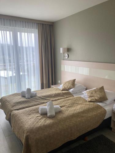 a hotel room with two beds with towels on them at Apartament Czarna Góra in Sienna