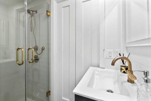 a white bathroom with a sink and a shower at 3BR Penthouse with Massive Private Rooftop in New York
