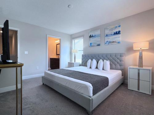 een slaapkamer met een groot bed en een televisie bij Balmoral Resort-140AA in Haines City