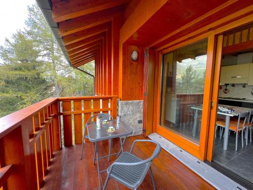 a porch of a cabin with a table and chairs at Affittimoderni San Simone - Appartamento Sci Sole in Valleve