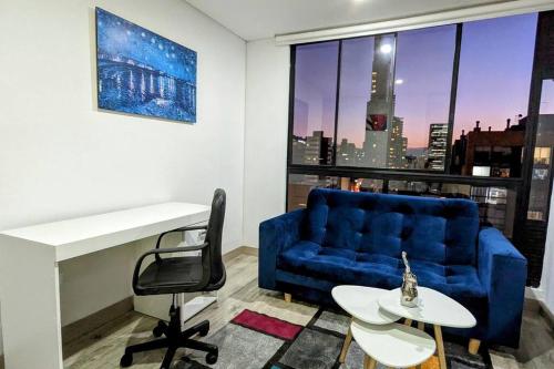 a living room with a blue couch and a table at Acogedor Apartaestudio Amoblado Centro Internacional, Bogotá in Bogotá