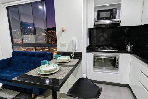 a small kitchen with a table and a microwave at Acogedor Apartaestudio Amoblado Centro Internacional, Bogotá in Bogotá