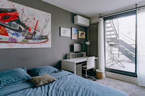 Schlafzimmer mit einem Bett, einem Schreibtisch und einem Fenster in der Unterkunft Luxury house for 8 - 3 terraces - By Askmefrance in Boulogne-Billancourt