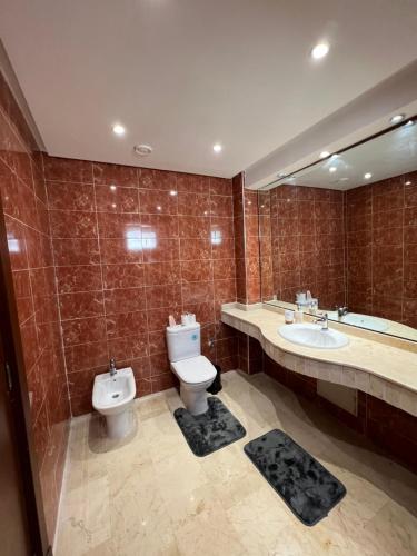 a bathroom with a toilet and a sink and a mirror at Magnifique appartement a la marina d agadir in Agadir