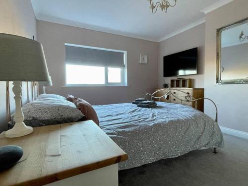 a bedroom with a bed and a table and a window at Scholes Park Drive, by the Seaside in Scalby