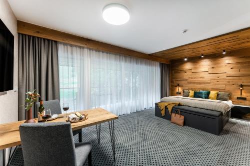 a hotel room with a bed and a desk and a table at Rezidence Alpina in Špindlerův Mlýn