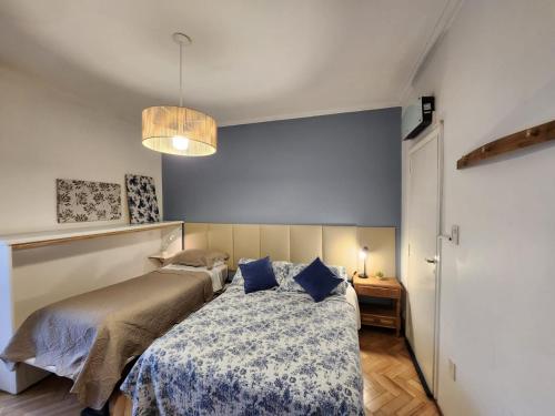 Schlafzimmer mit einem Bett mit blauer Wand in der Unterkunft Casa del Buen Viaje in Mendoza