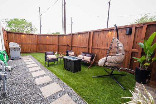 a patio with grass and a chair and a table at Downtown Escape - Backyard, Game room and Free Parking in Houston