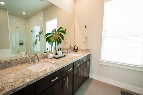 a bathroom with two sinks and a large mirror at Downtown Escape - Backyard, Game room and Free Parking in Houston
