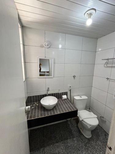 La salle de bains est pourvue d'un lavabo et de toilettes. dans l'établissement Flat Atlântico Neto, à Fortaleza