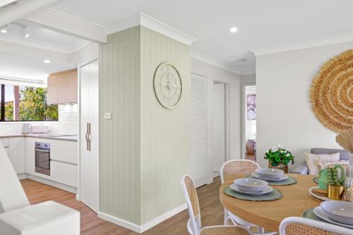 a kitchen and dining room with a table and chairs at Sunrise Point Beach House by Experience Jervis Bay in Vincentia